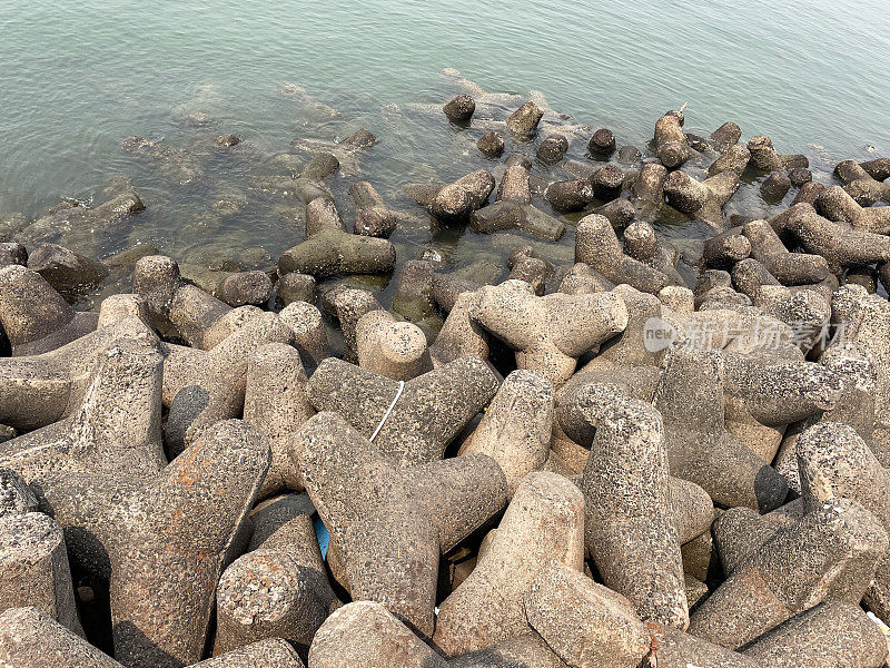 印度孟买的Marine Drive海堤特写图像，环环相扣，混凝土，四足块海防，海岸管理，防止侵蚀，海水和海浪，高架视图，重点放在前景上